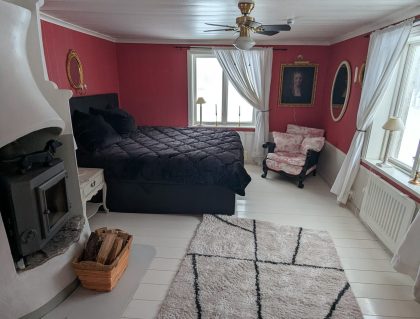 masterbedroom schlafzimmer mit doppelbett, kamin und ausblick ins grüne